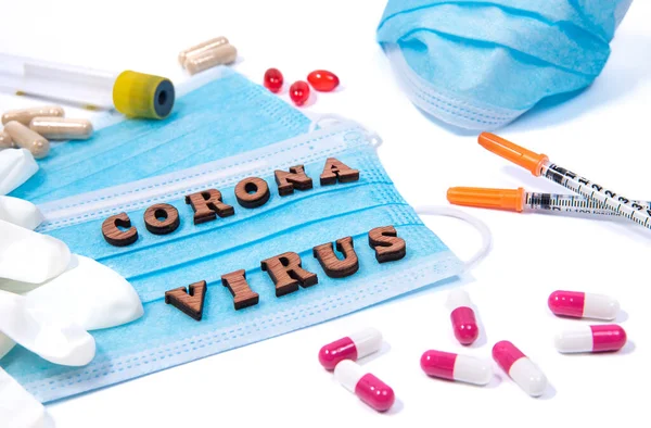白い背景に言葉コロナウイルスの文字の周りの医療機器 マスクや薬 ウイルスのパンデミック対策警報コンセプト — ストック写真