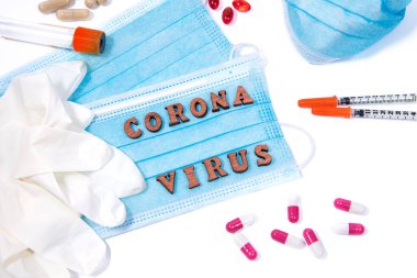 Tıbbi malzeme, maske ve haplar beyaz arka planda Corona virüsü harfleri etrafında. Virüs salgını koruma alarmı konsepti