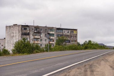 Eski gri, çok katlı Sovyet panel binasının ön cephesi. Pencereli eski Rus yerleşim evleri. Tipik Rus mahallesi..