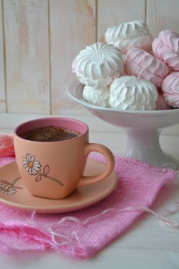 Ev yapımı zephyr ya da beyaz pejmürde masada pembe kahve eşliğinde marşmelov. Sevgililer Günü ya da Anneler Günü konsepti