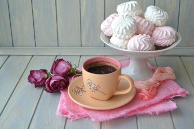 Zephyr Rus marşmelovu, açık mavi ahşap masada bir fincan sade kahve..