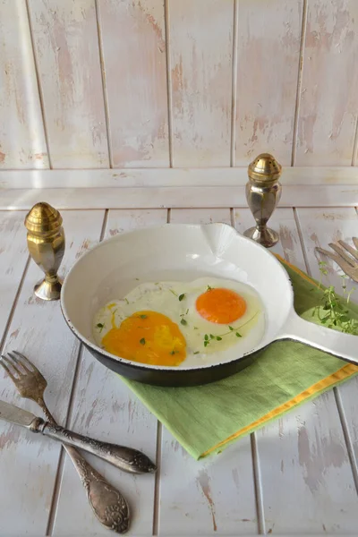 Gefrituurde roereieren in een pan op een armoedige achtergrond, verticaal beeld in landelijke stijl — Stockfoto