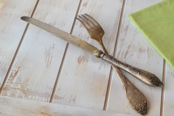 Staré příbory na ošuntělém dřevěném stole, starý stříbrný nůž a vidlička — Stock fotografie