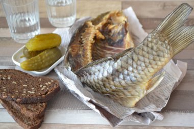 Kavramsal görüntü: salatalıklı votka ve salatalık turşulu gazete ve eski püskü bir masada ekmek..