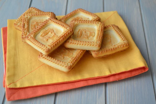 Galletas cuadradas o galletas amarillas con imagen samovar sobre mesa de madera azul . —  Fotos de Stock