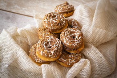 Karamelli kurabiyeli tatlı masa ya da bej rengi kırsal peçete ve eski püskü masa üzerinde kaynamış süt.