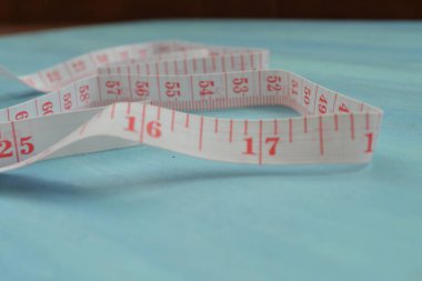 Mavi ahşap zemin üzerinde beyaz bir mezura ile yakın plan, kavramsal fotoğraf