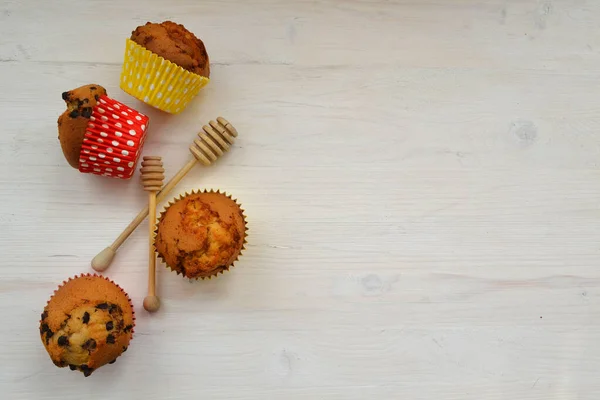Muffins aux pépites de chocolat sur fond blanc en bois, espace de copie — Photo