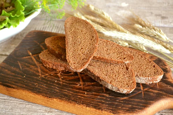 Нарізаний житній чорний хліб на обробній дошці крупним планом — стокове фото