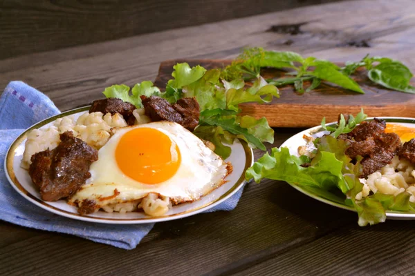 Bife de carne com ovo mexido e alface, café da manhã leve, mesa rústica de madeira preta — Fotografia de Stock