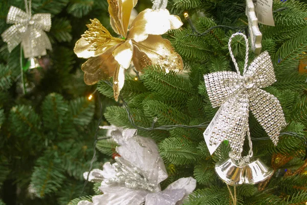 Weihnachtsschmuck in Gold und Silber mit Tannenzweigen, Weihnachtssternen und seidenglänzenden Bändern auf Fichtenstruktur — Stockfoto