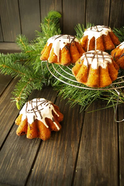 Piccolo pacchetto di dolci natalizi con glassa di zucchero su un tavolo di legno rustico con albero di Natale sullo sfondo, copiare lo spazio — Foto Stock