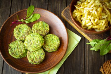 Vejetaryen nohut köftesi ya da pirzola. Sağlıklı vejetaryen diyeti. Sebzeler, yeşil ıspanak, brokoli pirzolası ve patates kızartması. Üst görünüm