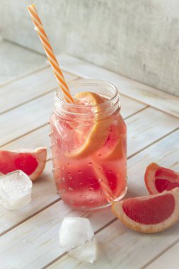 Kırmızı greyfurt limonata, buz küpleri ve damlacıklar..