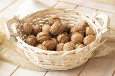 Ceviz çekirdekleri ve sepetteki cevizler eski püskü ahşap masada.