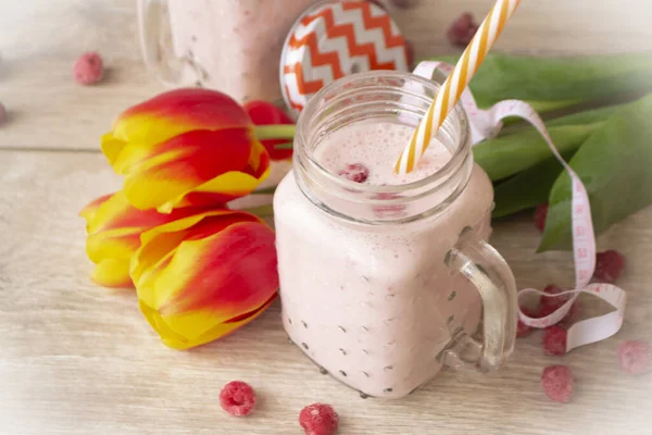 Batido de frambuesas con tulipanes coloridos y cinta métrica — Foto de Stock