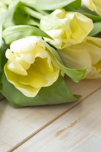 Tulipanes amarillos sobre fondo rústico de madera, imagen vertical — Foto de Stock