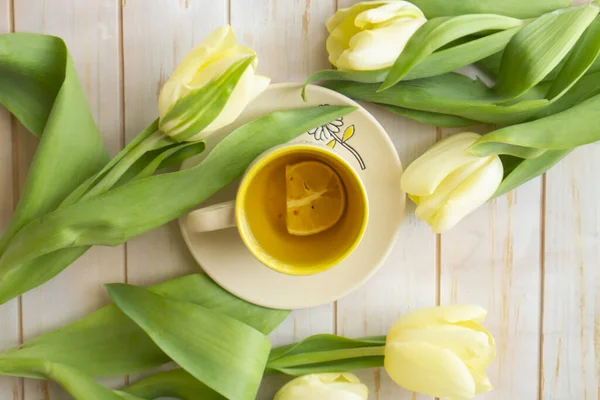Afternoon tea with lemon, and yellow tulips on the light wooden background. Tea party. Spring mood, Mothers day concept. — 图库照片