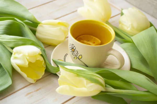 Still life tea drinking with pastel yellow tulips — Stockfoto