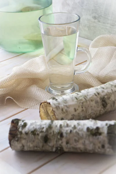 Glasse de sève de bouleau sur table en bois minable avec branche de bouleau — Photo