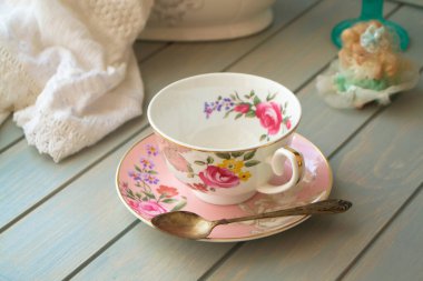 Turkuaz masa üzerinde pembe porselen çay fincanı..
