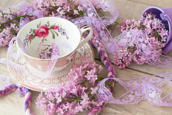 ライラックの紫色の開花枝を持つお茶のヴィンテージカップ 招待状の背景 グリーティングカードのデザイン — ストック写真