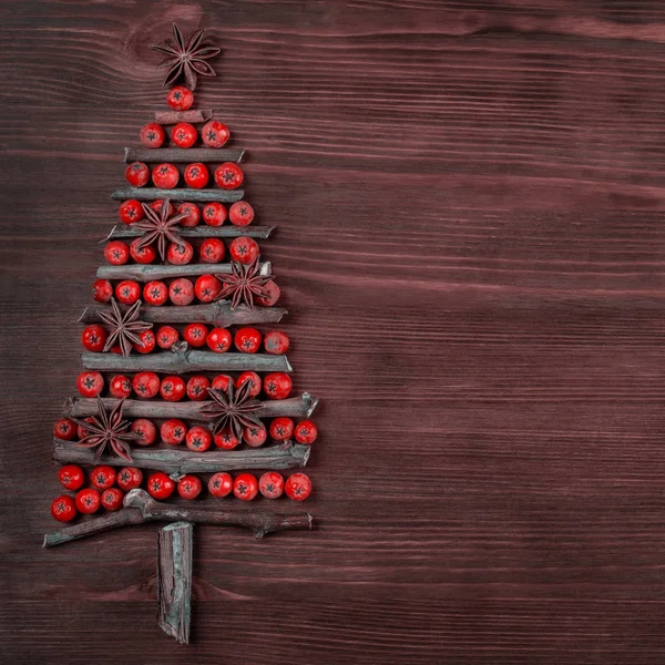 圣诞树是用木枝和树莓做成的 新年庆祝理念与圣诞树与星光和红宝石装饰的木材背景 文本的位置 平面布局 顶部视图 复制空间 — 图库照片