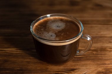 Kahve fincanı ve kahve çekirdekleri ahşap masada. Seçici odak