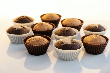 Çikolatalı keklerin üzerine pudra şekeri serpiştirilmiş. Pasta süsleme keki. Pastanın üzerine şeker serpilmiş. Lezzetli yemekler. Siyah ve beyaz, ışık ve gölge.