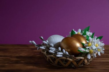 Söğüt ağacı ve sarı çiçeklerle dolu sepetteki Paskalya yumurtaları. Tatil için hazırlık. Paskalya süslemeleri