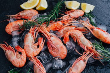 Kaplan karides ile limon, limon, biberiye ve kara biber baharat taş zemin üzerine.