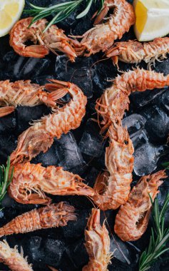 Kaplan karides ile limon, limon, biberiye ve kara biber baharat taş zemin üzerine.