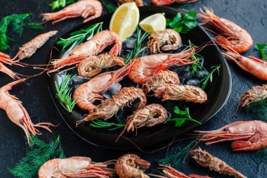 Buz, limon ve biberiye ile bir tabak karides