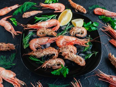 Buz, limon ve biberiye ile bir tabak karides