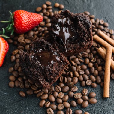 Kek kahve çekirdekleri ve çilek karanlık bir arka plan üzerinde