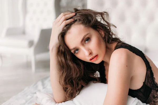 Seksi esmer kadın saçlarını ayarlama yatakta yatıyordu