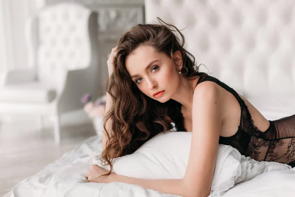 Seksowna brunetka w łóżku w bieliźnie — Zdjęcie stockowe