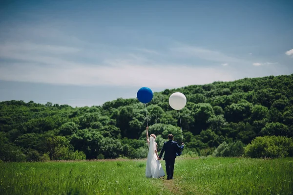 bride and groom walking with balloons