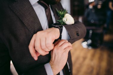 Kahverengi ceketli damat saatler koyar