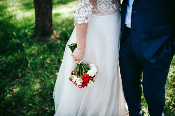 花束と緑豊かな庭園で黒い服を着て新郎古典的な白いドレスの花嫁 — ストック写真