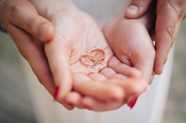 Yeni evliler alyans elinde tutan