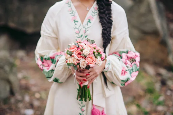 刺繍入りの白いドレスの若い女性が花を保持します — ストック写真