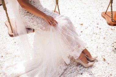 Muhteşem gelin güneşli bir günde bir salıncak üzerinde oturuyor