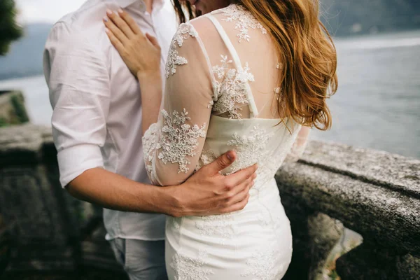 イタリアのコモ湖で石造りのバルコニーに立っている花嫁を持って新郎 — ストック写真