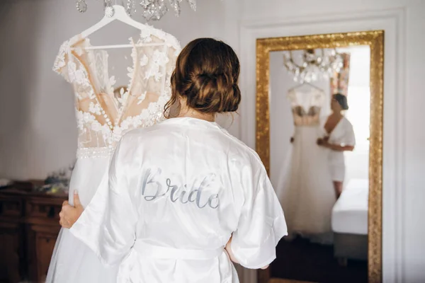 bride in a white silk robe with the inscription \