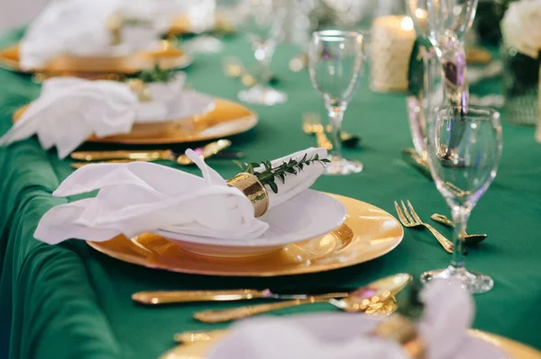 Festive Table Served Golden Dishes Glasses Decorated Branches Greenery Green — Stock Photo, Image