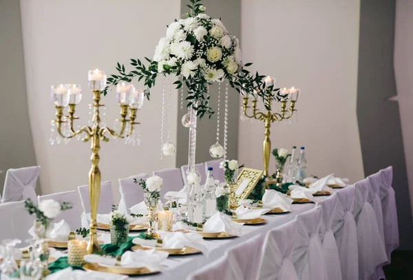 祭りのテーブルは 料理を提供し 緑の枝で飾られました 花の組成とキャンドルスティック 結婚式のパーティーの領域に立つ — ストック写真