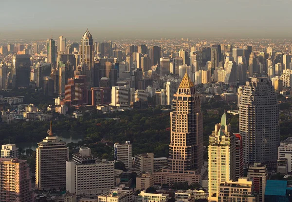 Gökdelenler ve günbatımı bir park Bangkok, Tayland — Stok fotoğraf