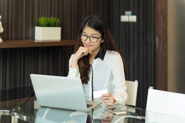 An asian business woman using a credit card in front of a laptop — Stock Photo, Image