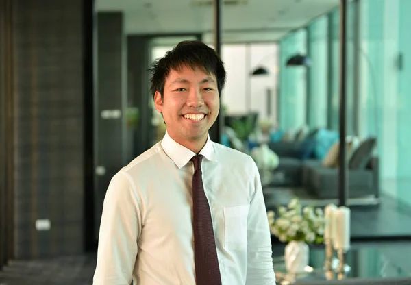 Un uomo d'affari asiatico che lavora e sorride in ufficio, persona — Foto Stock